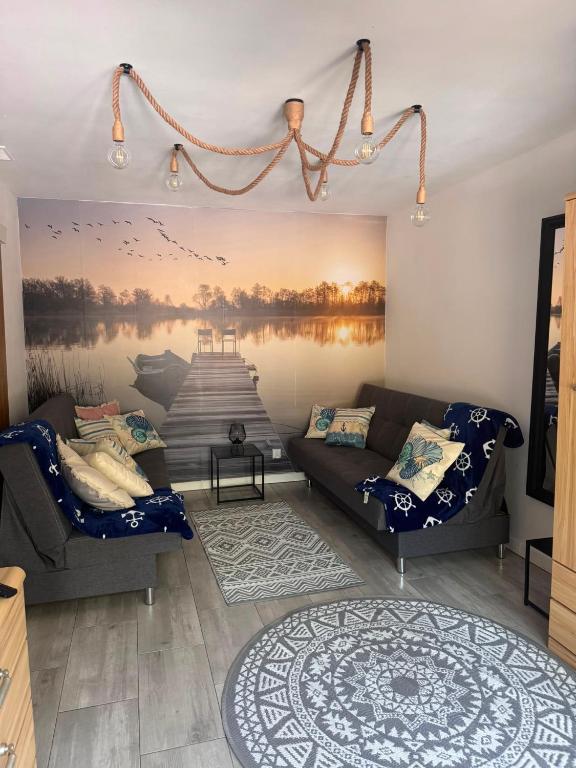 a living room with a couch and a painting on the wall at APARTAMENT PLUS in Włodawa