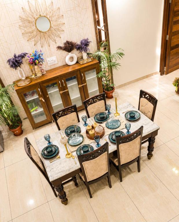 a dining room table with blue dishes on it at Entire 3BHK Villa for Families & Groups with Kids Play Area in Jaipur