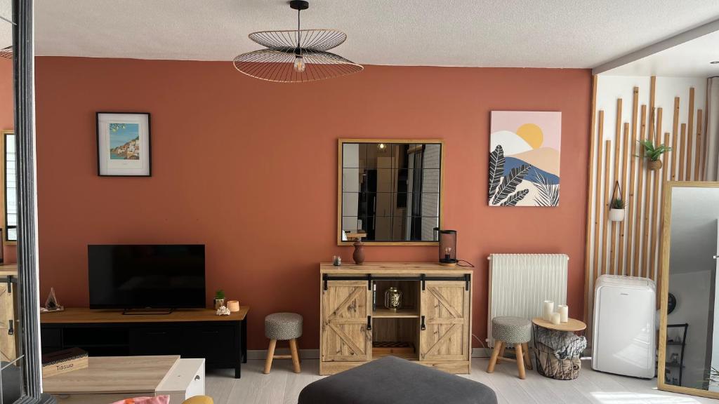 a living room with an orange wall and a television at Un,Deux,Trois...Soleil in Le Pradet