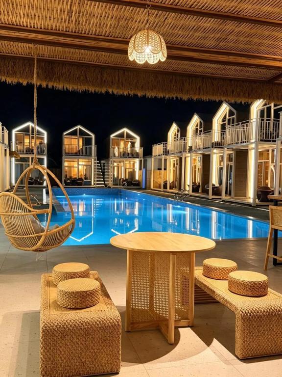 a large pool with a table and chairs in front of it at All Season Resort Semporna in Semporna