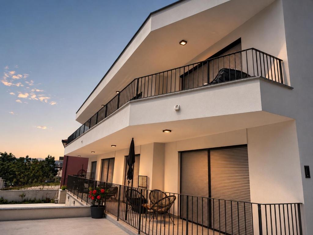 a large white house with a balcony at Apartments Villa Nikola- one minute to the beach in Gradac