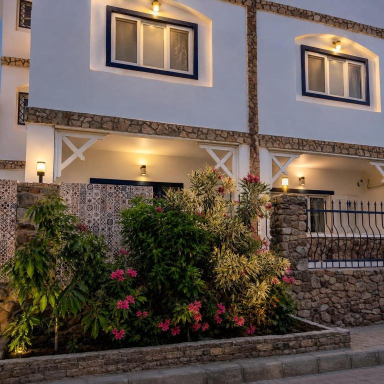a building with flowers in front of it at Tarbouche House Dahab in Dahab