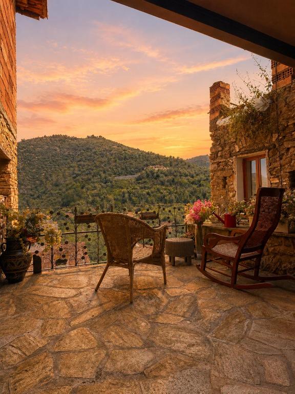 a patio with two chairs and a table with a view at La Rocca Sospesa - Castello in Apricale