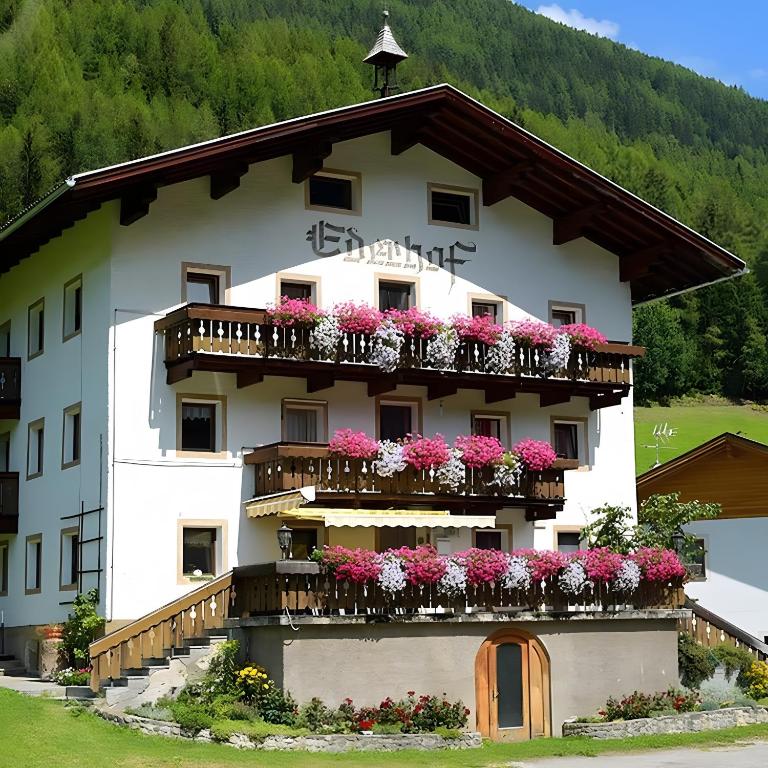 a building with flowers on the balconies of it at Bed and Breakfast Ederhof in San Giacomo
