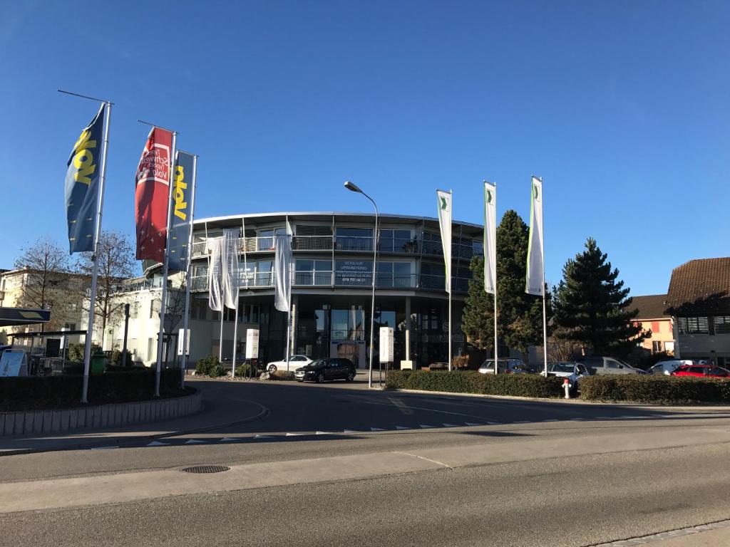 un bâtiment avec drapeaux en face d'une rue dans l'établissement Berger Zentrum, à Berg