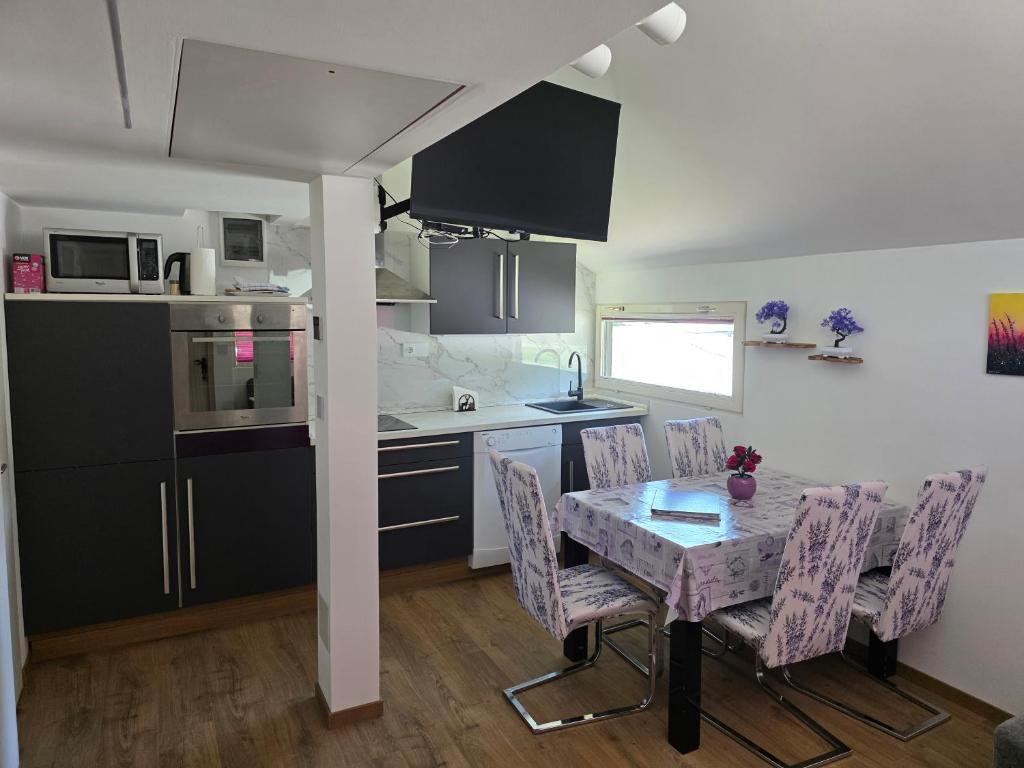 a kitchen with a table and chairs in a room at Spa Cottage Lavender in Terme Čatež in Čatež ob Savi