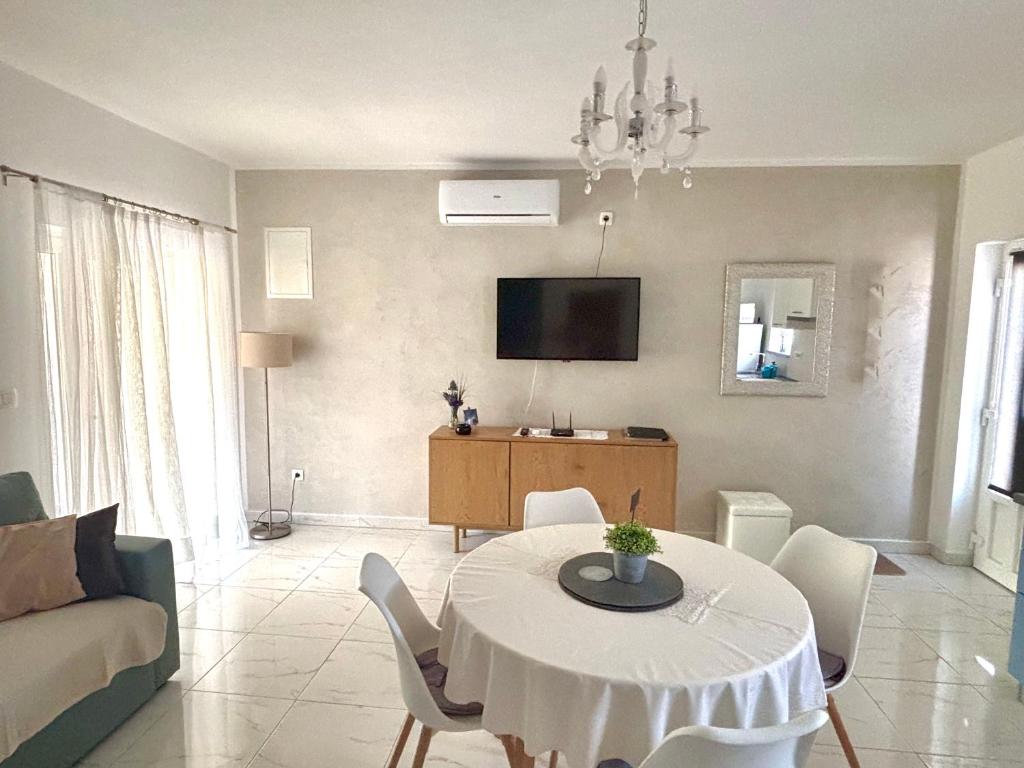 a living room with a table and a tv at Apartmani Stellar in Malinska
