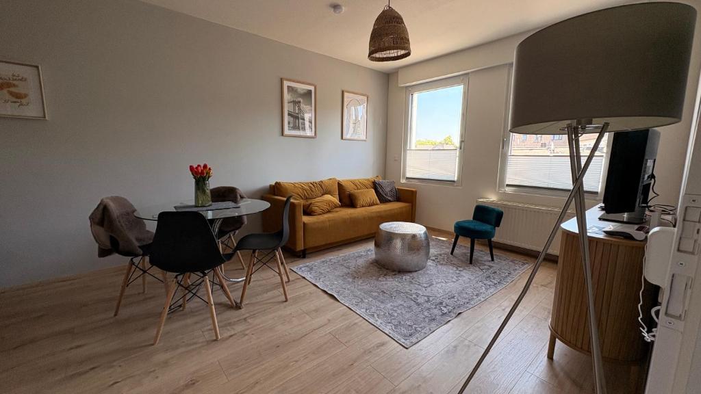 a living room with a couch and a table and chairs at BrunnenApart Nova in Bad Oeynhausen