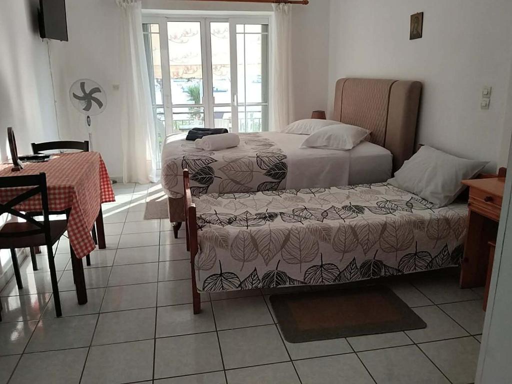 a bedroom with two beds and a table and a table and chairs at Geni Bay 2 in Lefkada