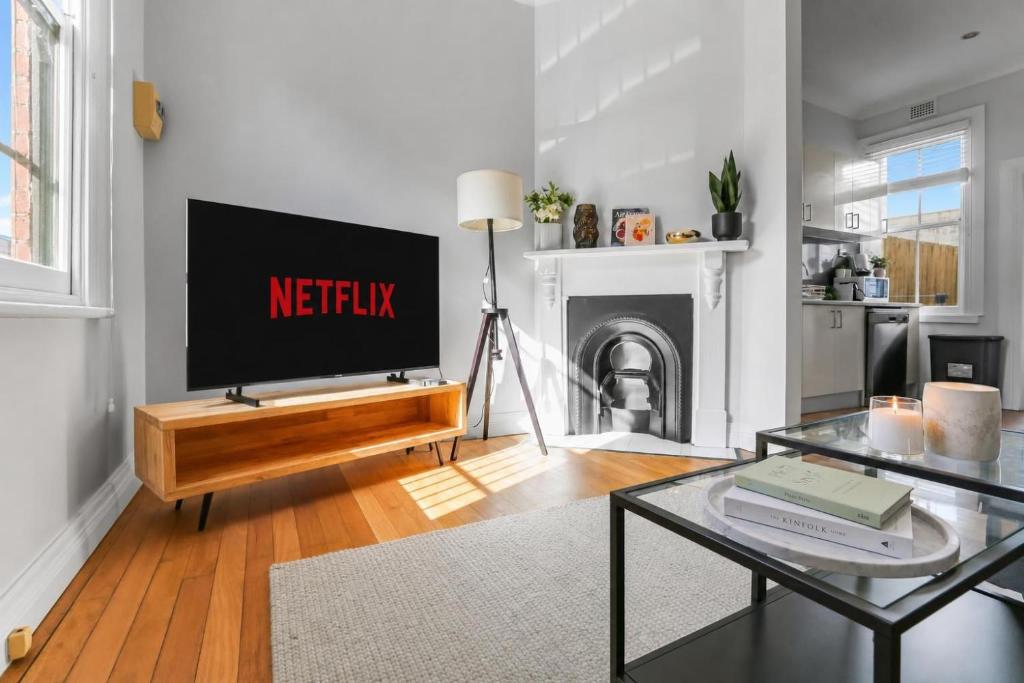 a living room with a tv and a table at 2 Bedroom House Woolloomooloo in Sydney