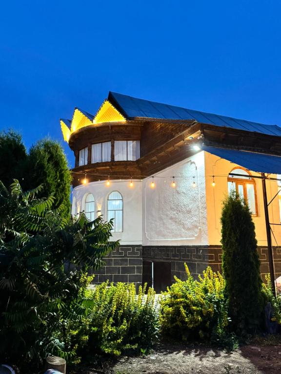 a house with a building with a roof at Crown Inn & Spa in Karakol