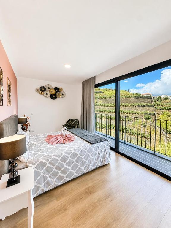 a bedroom with a bed and a large window at Villa Bavaria B in Ponta do Sol