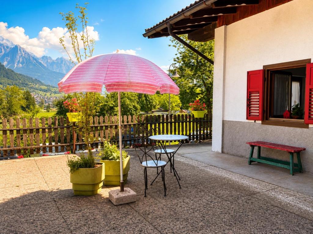 a table and chairs under an umbrella on a patio at Casa Cappuccetto in Imer