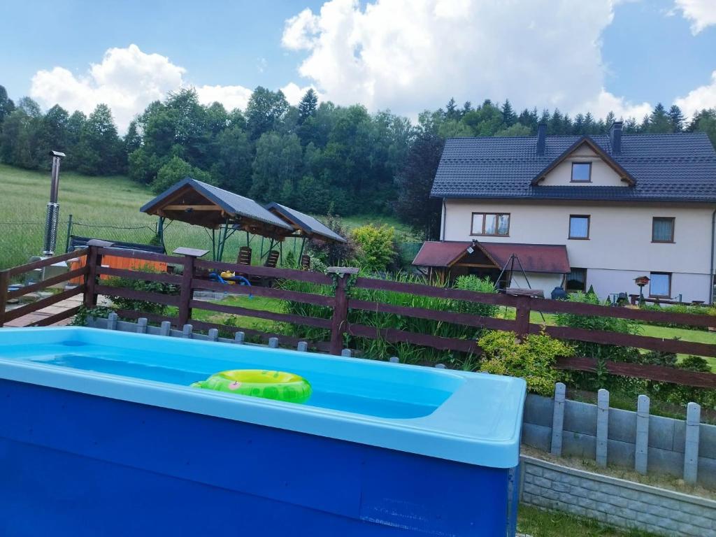 a hot tub in a yard next to a house at Dom w górach na wyłączność Agro Zibi in Korbielów