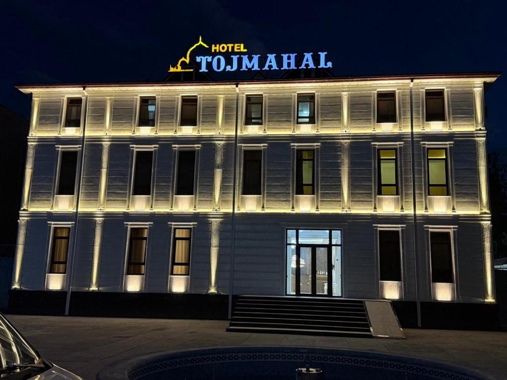 a white building with a sign on top of it at Toj Mahal Hotel in Takchilik