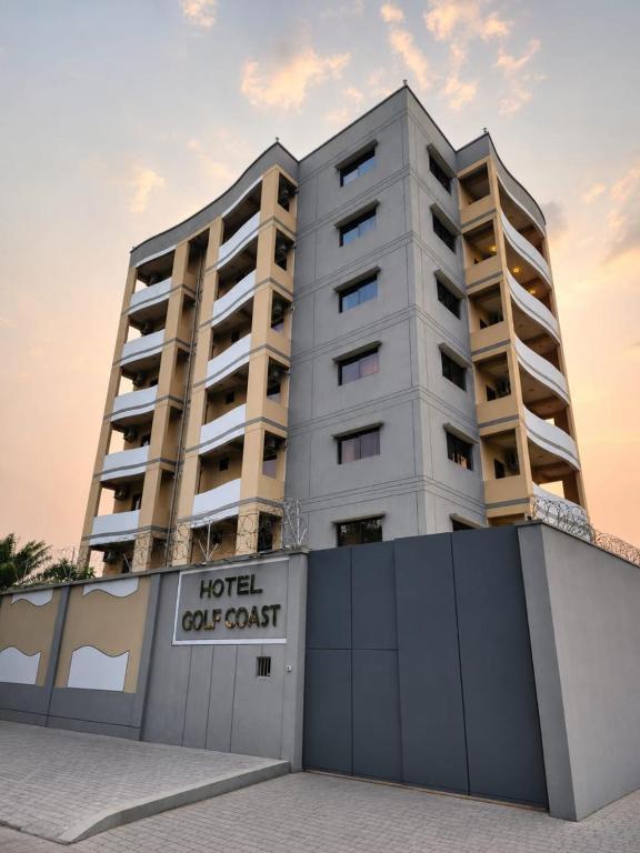 a hotel apartment building with a sign in front of it at Hotel Golf Coast in Kinshasa