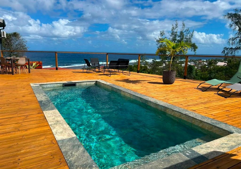 a swimming pool on a deck with a view of the ocean at La Villa Bleu Lagon in Petite Île