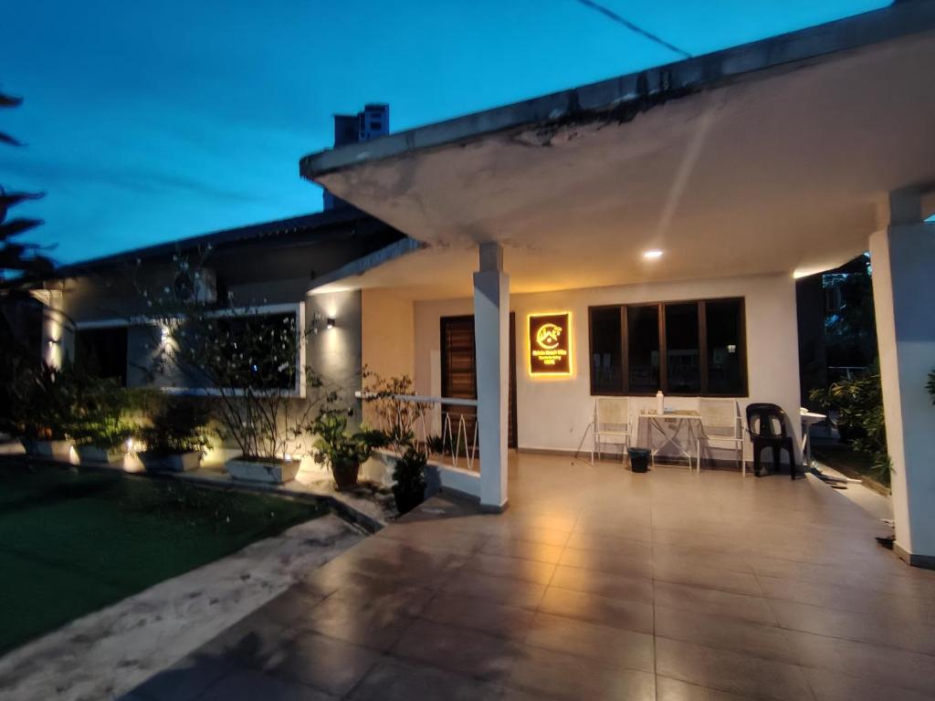 a house with a lit up patio at night at MELAKA BEACH VILLA ( A TYPE ) in Kelebang Besar