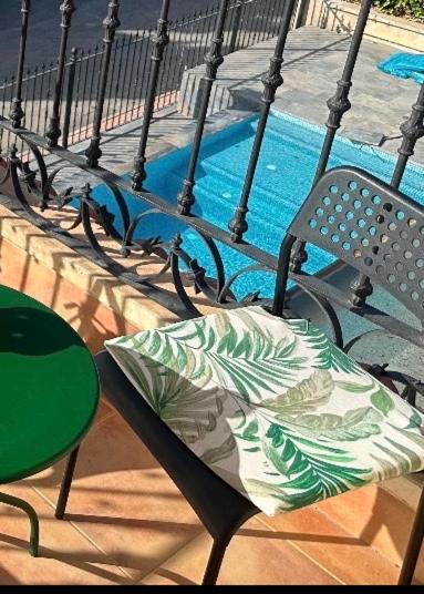 a pillow sitting on a chair next to a swimming pool at Solea Alcayna in La Alcayna