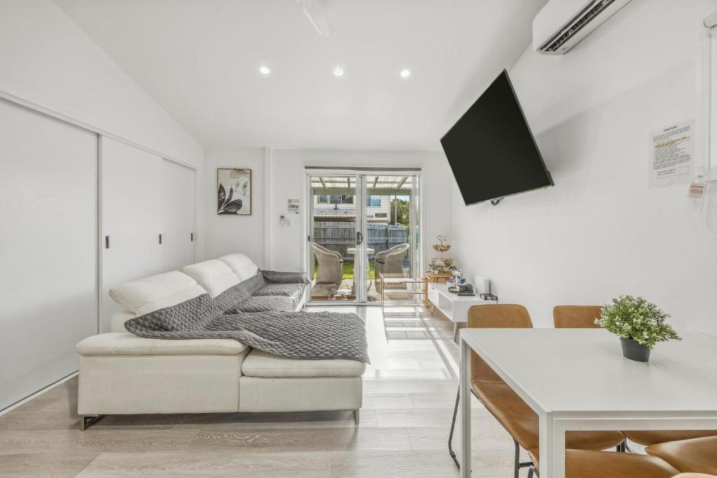 a white living room with a couch and a table at Lovely Hidden Gem in Redcliffe in Redcliffe