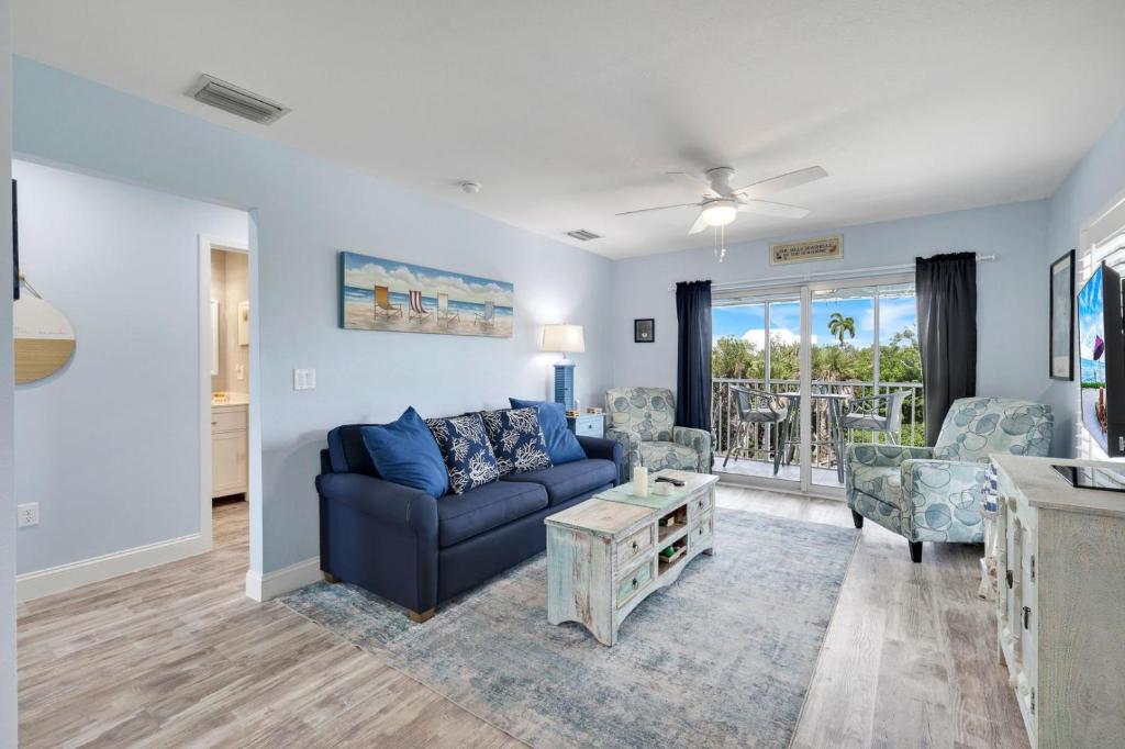 a living room with a blue couch and chairs at Seashells #45 in Sanibel