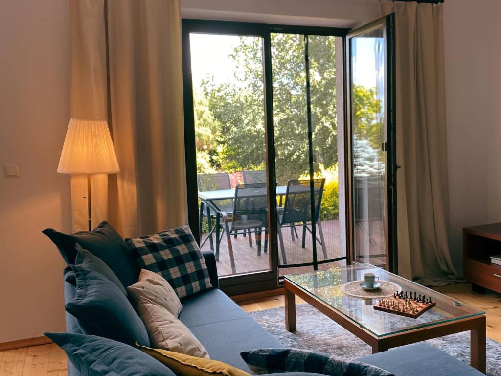 a living room with a couch and a glass table at Cozy Garden Apartment Near Krakow - Free Parking in Gaj