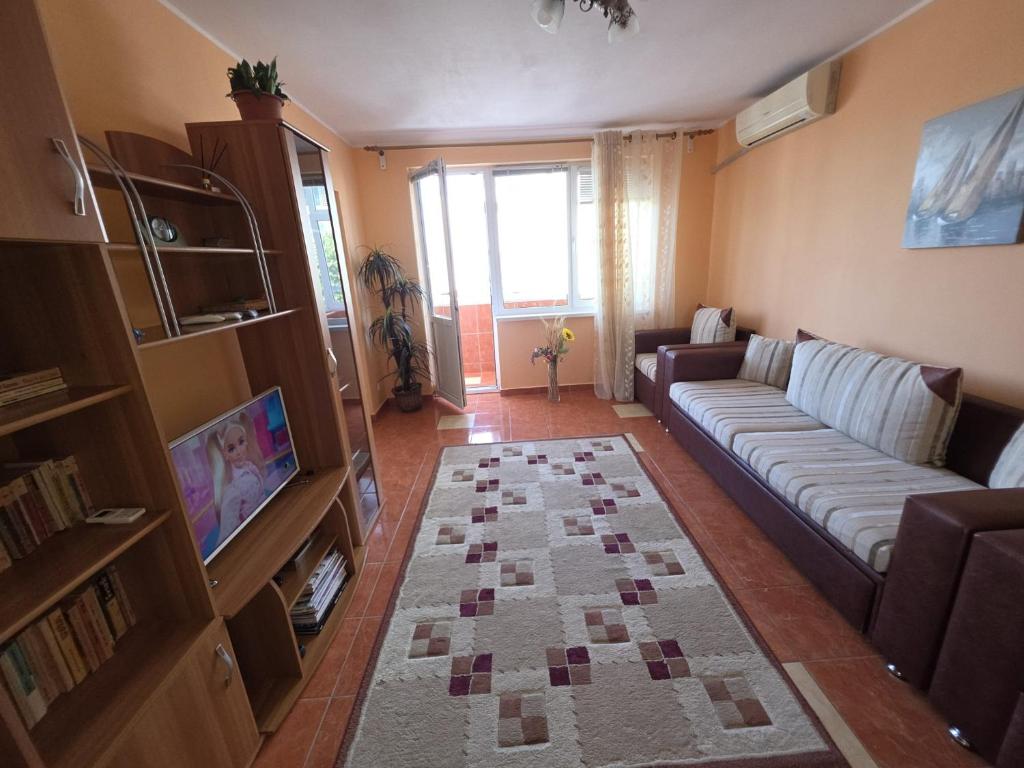 a living room with a couch and a tv at Apartament Gabriela in Mangalia