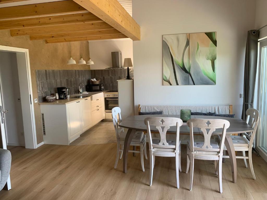 a kitchen and dining room with a table and chairs at Fewo Fernblick in Much