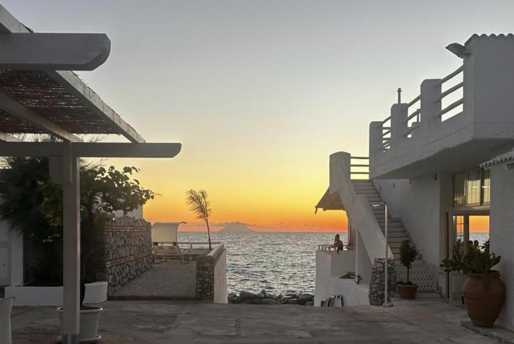 a view of the ocean at sunset from a house at Villaggio Hotel Agrumeto in Capo Vaticano