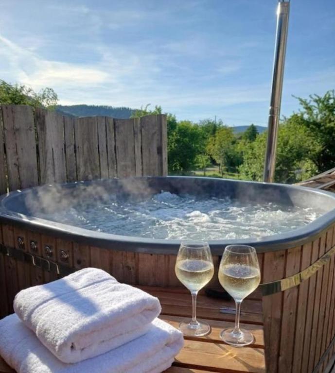 two glasses of white wine sitting next to a hot tub at Entre-parenthèses,gîte avec SPA,proche Gérardmer et La bresse in Vagney