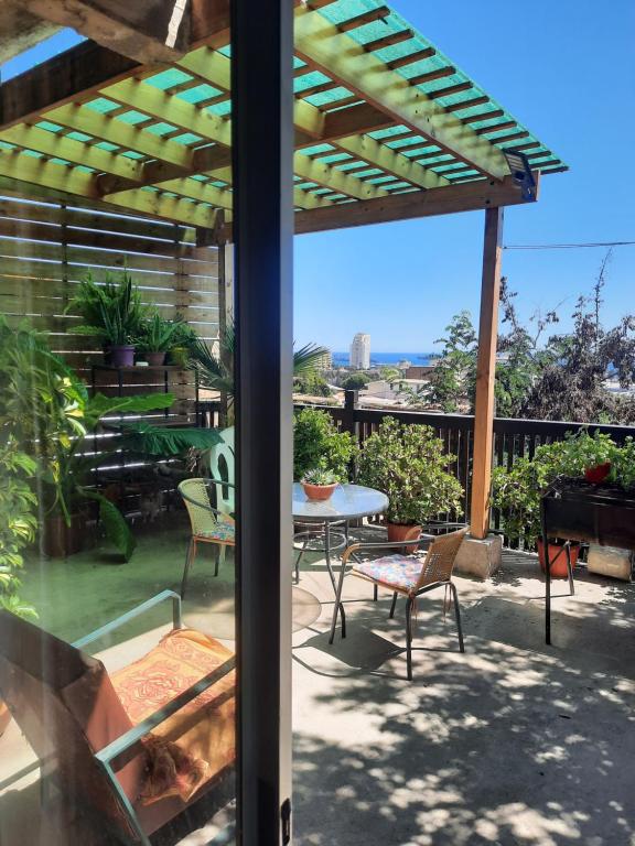 a patio with a table and chairs and a pergola at Loft vista a la bahía in Valparaíso