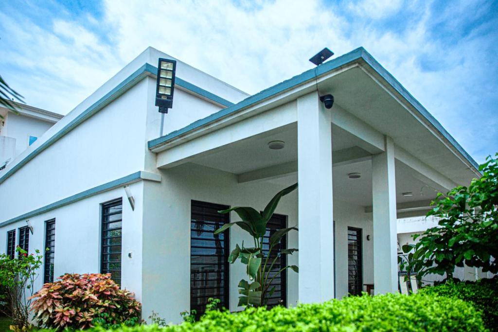 a white house with a blue roof at Villa Mélaure in Abomey-Calavi