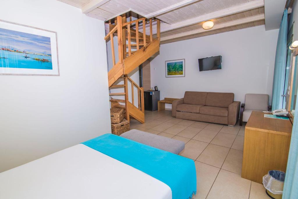 a bedroom with a bed and a living room at Grand Boutique in Vasiliki
