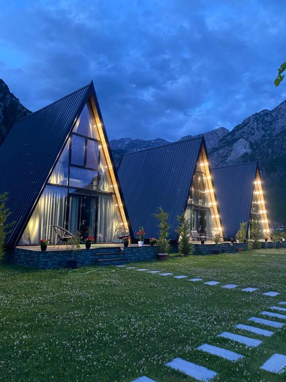 a house with a black roof and two trees at Monark Villas in Theth