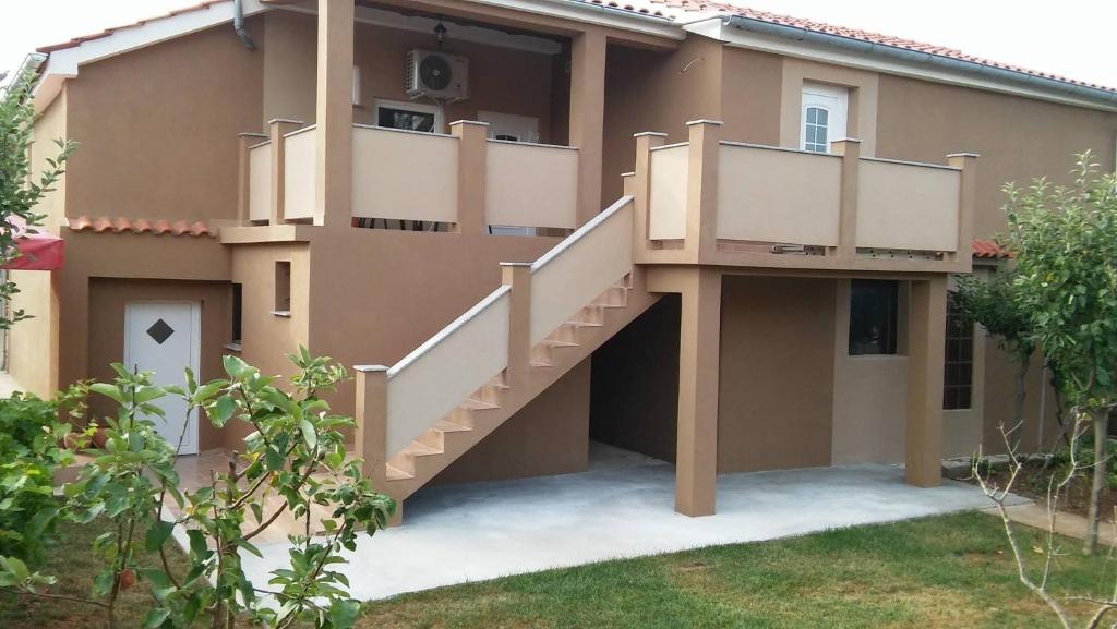 a house with stairs on the side of it at Apartments Anicic Coric in Omišalj