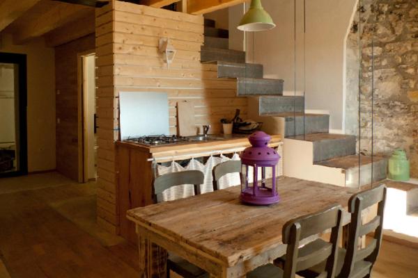 a kitchen with a wooden table with a purple lamp on it at Agrigrà in Valbrenta 