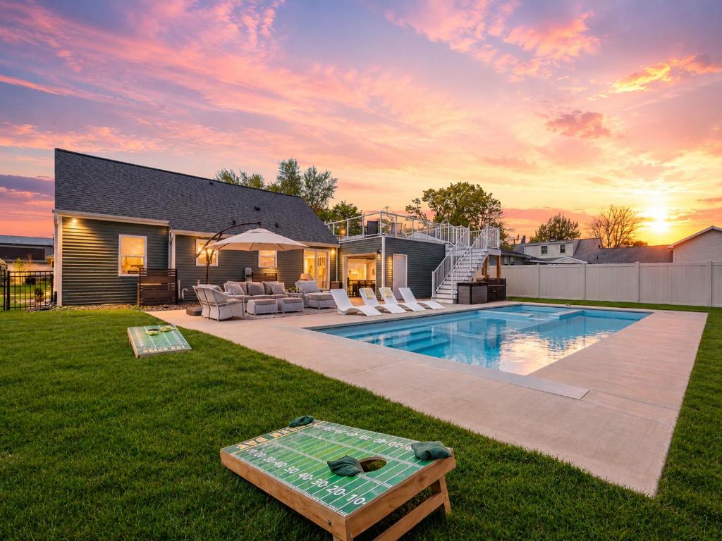 a backyard with a swimming pool and a house at Lambeau View Pool Rooftop Entertainment Room in Green Bay