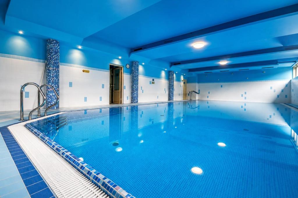 a large indoor pool with a blue ceiling at Apartament Giewont in Kościelisko