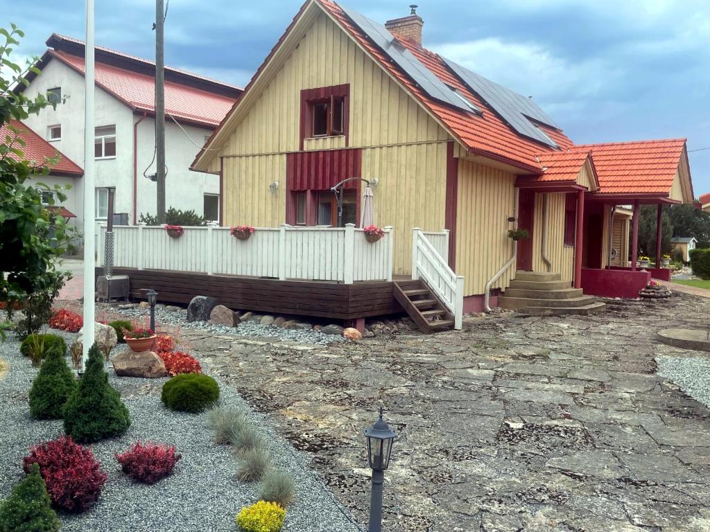 a house with a red roof and a yard at Kalvi tee Puhkemaja in Viru-Nigula