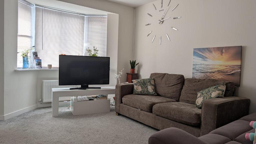 a living room with a couch and a flat screen tv at NG Property in Glasgow