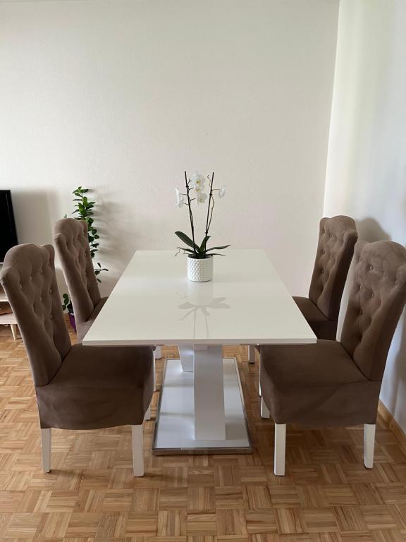 a white dining room table with chairs and a vase with flowers at Apartment in Stäfa in Stäfa