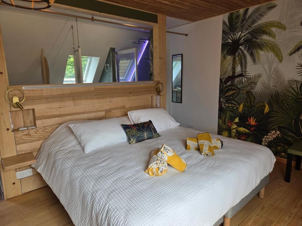 a bedroom with a large white bed with two stuffed animals on it at Chambre et table d'Hotes Manava Loretta in Bannalec