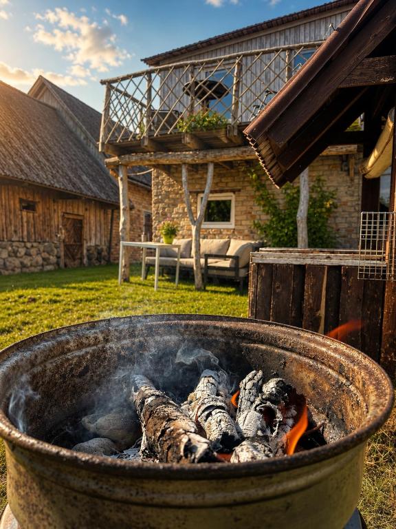 a pot filled with fish cooking on a grill at Cenkones Bungalow in Cenkoņi