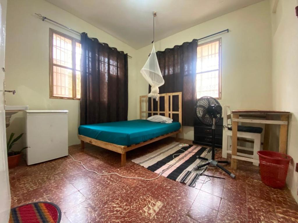 a bedroom with a blue bed in a room with windows at Homestay in Wilkinson road in Freetown