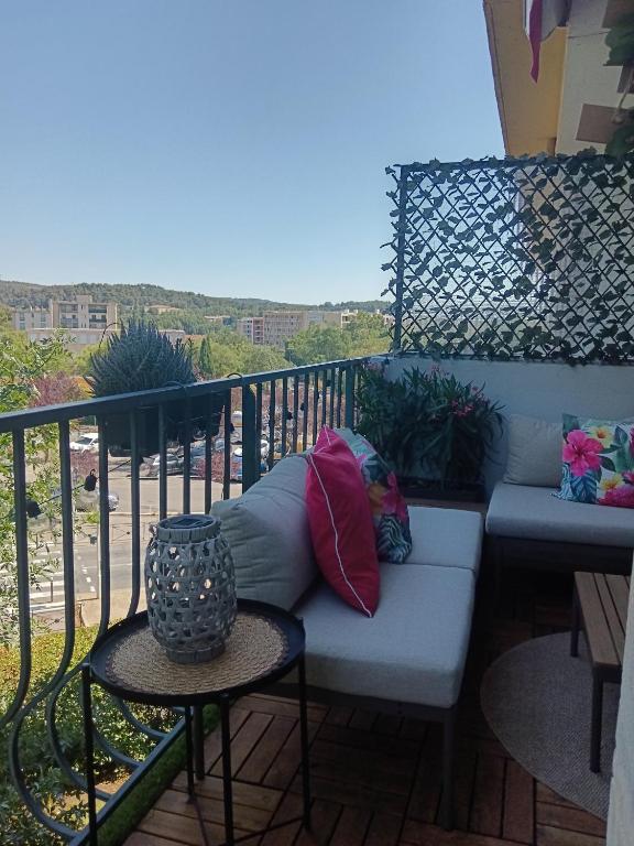a couch sitting on a balcony with a view at Cosy T3, proche centre ville in Aix-en-Provence