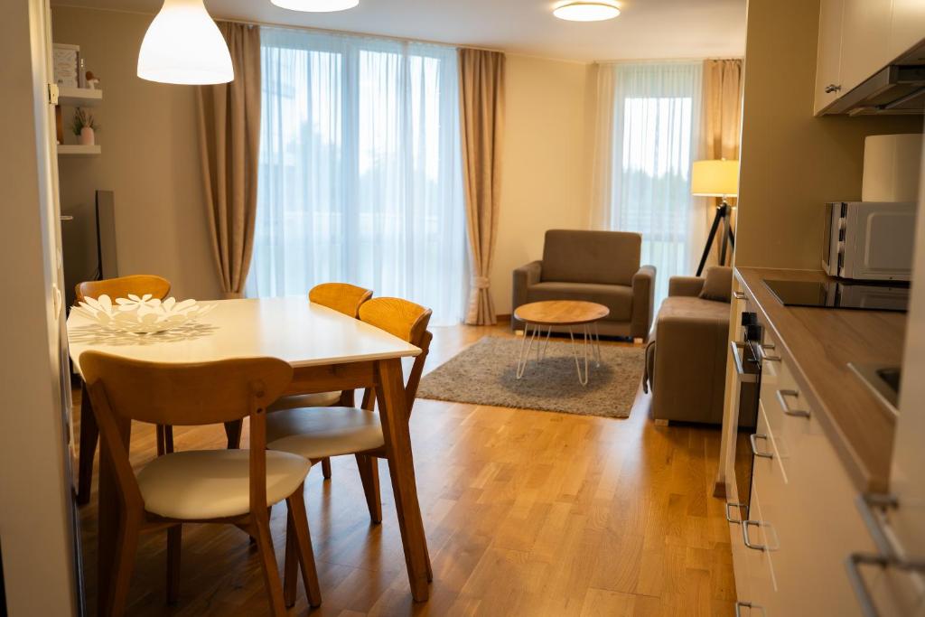 a kitchen and living room with a table and chairs at Naglio apartamentai Elija in Šventoji