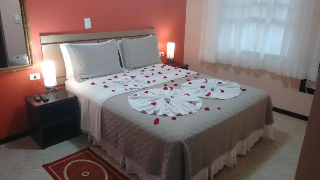 a bedroom with a large bed with red roses on it at Pousada Estrela do Mar in Ilha do Mel