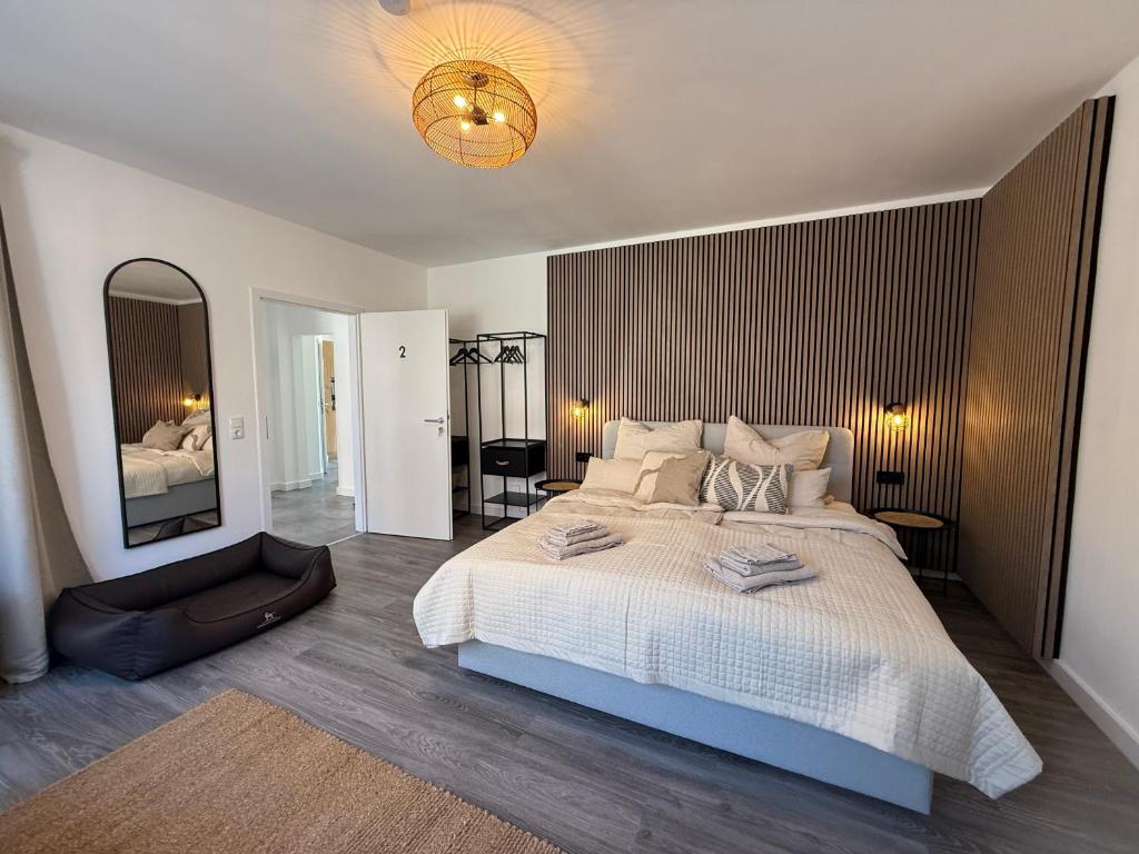 a bedroom with a large bed and a mirror at Urban Nest Burg - Design Apartment mit Smart-TV, Self Check-in & Free Parking in Burg
