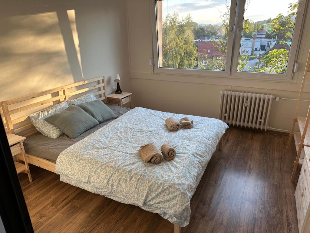 a bedroom with a bed with two slippers on it at Apartmán Volary in Volary