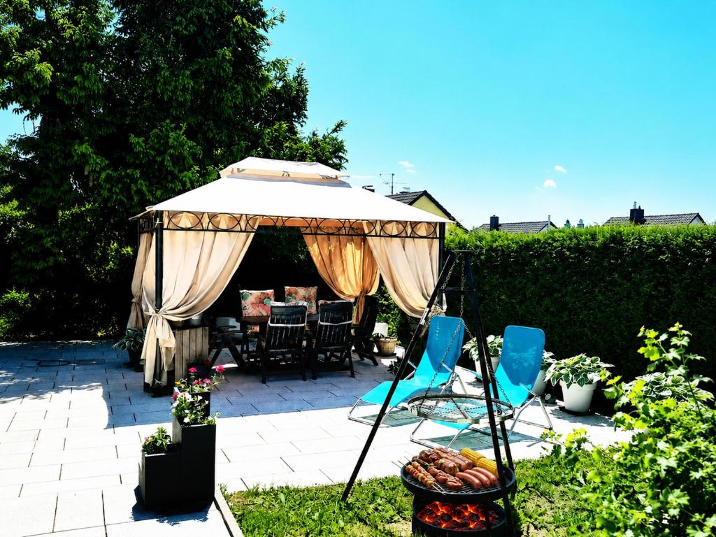 a patio with an umbrella and chairs and a table at Gelbe Koffer - Design-Maisonette in Schiffweiler - private Terrasse & Grill - nahe Wald & See - Self-Check-in - 2 Parkplätze in Schiffweiler